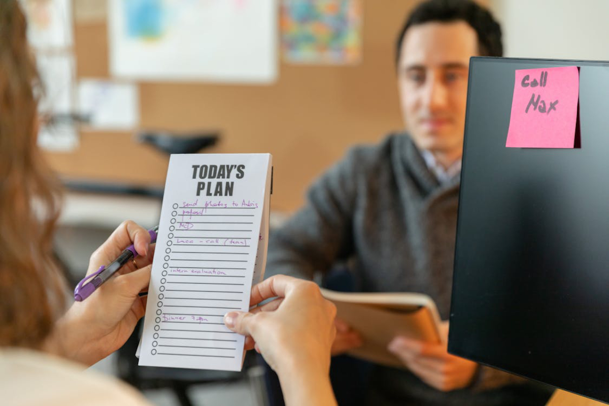 A notepad titled Today's Plan is held by a person, featuring a to-do list with tasks.