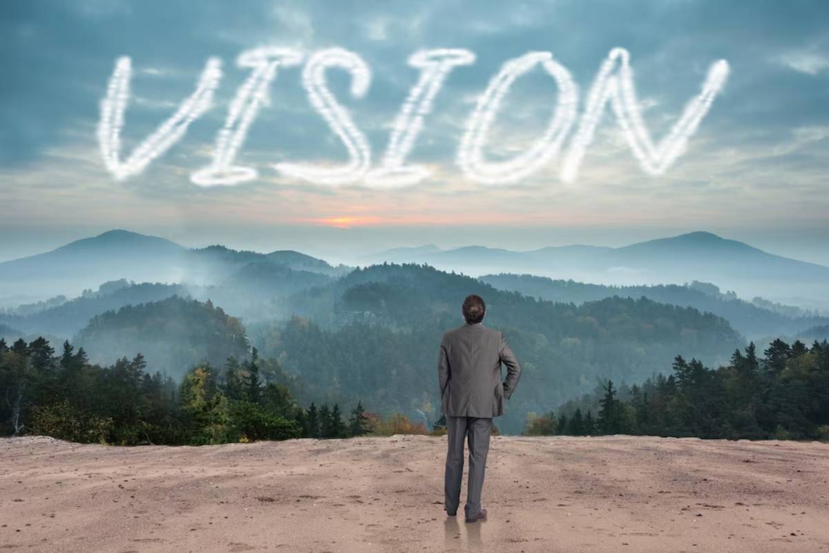 Man in a suit looking at cloud mountains with the word 